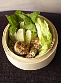 Chicken burgers with lime wedges & lettuce in steaming basket