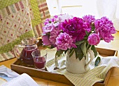 Peonies and fruit juice on tray
