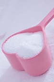 Granulated sugar in heart-shaped dish