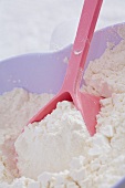 Flour with spoon in heart-shaped bowl