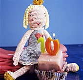 Petit four with birthday candles and crocheted doll