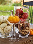 Squashes, nuts and pomegranates in glass containers