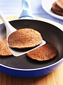 Chocolate pancakes in a frying pan