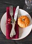 Place-setting with rose hips and pumpkin