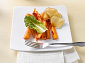 Carrot sticks with crisps and lettuce leaf