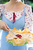 Woman holding a mixed berry pie with filo pastry