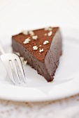 A piece of chocolate truffle cake with elderflowers