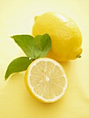 Zitronenhälfte und ganze Zitrone mit Blättern