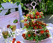 Etagere mit Erdbeeren und Kräutern