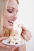 Young woman eating nougat