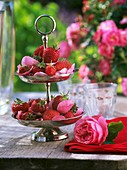 Etagere mit Erdbeeren und Rosenblüten