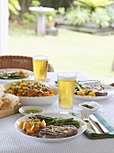 Steak and vegetables on laid table out of doors