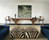 Wohnzimmer mit Polsterhockern im Zebra-Look, länglichem Konsolentisch & modernem Wandgemälde