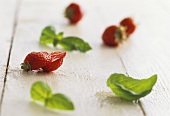 A display of strawberries and basil leaves