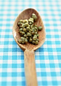 Small capers on a wooden spoon
