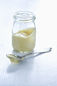 Mayonnaise im Glas und auf Löffel