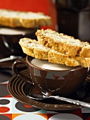 Walnut biscotti on a cappuccino cup
