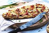 Tarte flambée with bacon, onions, spring onions and cheese