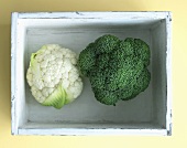 Cauliflower and broccoli in a wooden crate, seen from above