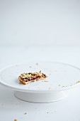 The remains of a damson crumble cake on a cake stand