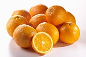 Mehrere ganze Orangen und eine Orangenhälfte