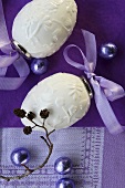 Two porcelain eggs with purple bows