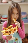 A girl eating faworki (deep-fried pastry, Poland)