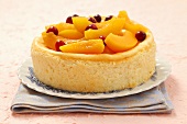 Cheesecake with peach slices and cranberries