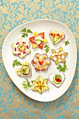 Various canapes with ham, cheese and vegetables