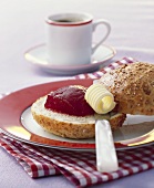 Wholemeal roll with butter and strawberry jelly