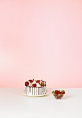 Cake decorated with strawberries & dish of strawberries