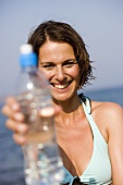 Woman with a bottle of mineral water on the beach