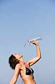 Young woman refreshing herself with water