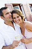 Man and woman clinking glasses of white wine