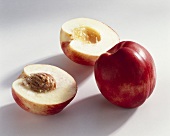 Whole and halved nectarine (variety: Queen Ruby)