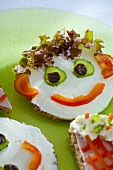 Soft cheese, salad & vegetables on wholemeal bread (a face)
