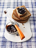 Plum and honey jam in small dish and on wholemeal bread