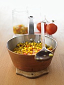 Home-made corn relish in a copper pan
