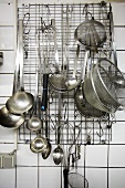 Assorted kitchen utensils hanging on a wall