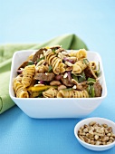 Pasta and sausage salad with pine nuts