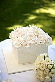 Square wedding cake with a mass of roses