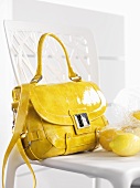 Yellow handbag and lemons on a chair