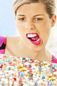 Frau schneidet Grimasse beim Anblick von Tabletten