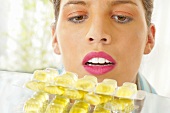 Frau blickt auf Tabletten in Blisterverpackung