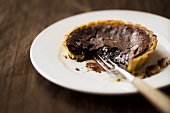 Small chocolate pecan tart, partly eaten