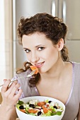 Young woman eating Greek salad