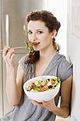 Junge Frau isst griechischen Salat