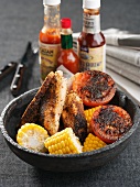 Fried chicken breast with tomatoes and corn on the cob