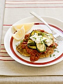 Breaded veal escalope with tomato sauce and courgettes