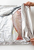 Wrapping red mullet in aluminium foil